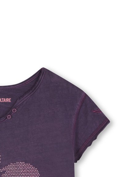 Paarse katoen t-shirt met ronde hals, twee knopen en korte mouwen. Heeft een stippenpatroon en contrasterende stiksels.