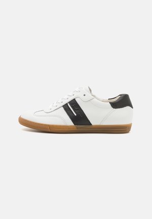 Sneaker in pelle bianca con accenti neri, punta rotonda, suola piatta in gomma, e chiusura con lacci. Presenta un design con pannello laterale testurizzato.
