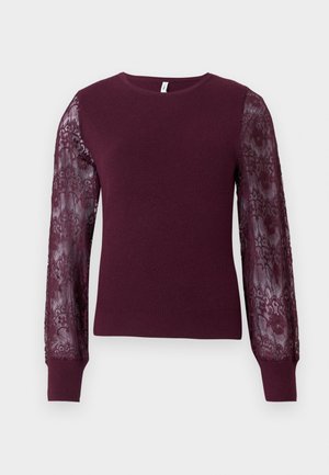 Burgunderfarbener Strickpullover mit langen durchsichtigen Spitzenärmeln. Rippstruktur an den Bündchen und am Körper, mit einem klassischen Rundhalsausschnitt.