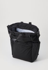 Fekete nylon bevásárlótáska, számos zsebbel, strapabíró vállpántokkal és tágas belső térrel, világosszürke béleléssel.