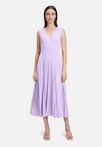 Lavendelfarbenes ärmelloses Kleid mit Wickeldesign, ausgestattet mit einem gerafften Bund und fließenden Falten. Weicher, leichter Stoff mit glatter Textur.