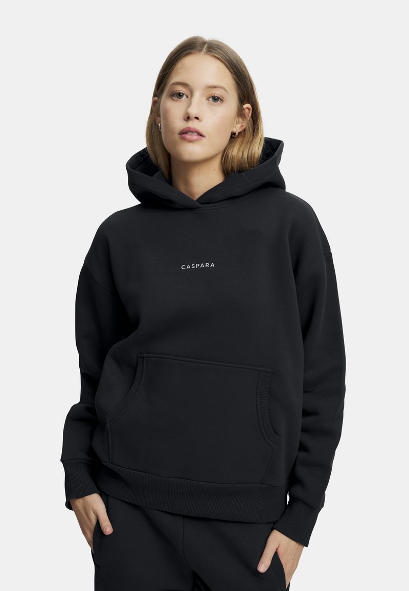 Svart hettegenser med frontlomme, ribbede mansjetter og nederkant. Forsiden har en liten, hvit logotekst. Laget av mykt stoff.