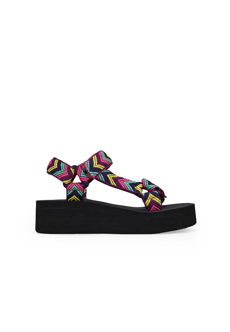 Sandalias de plataforma negras con una correa tejida colorida en un patrón de chevron en rosa, azul y amarillo; diseño anudado para un detalle adicional.