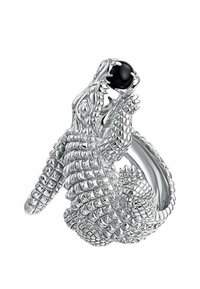 Anillo de plata diseñado como un cocodrilo, con escamas detalladas y una piedra preciosa negra en su boca. Superficie suave y brillante con patrones intrincados.