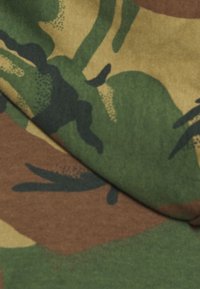 Tela de camuflaje con tonos variados de verde, marrón y negro, con patrones abstractos similares a hojas y una textura suave.