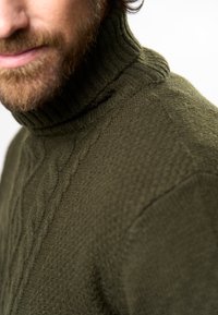 Pulover verde măsliniu cu guler înalt, dintr-un material tricotat texturat, având un guler rib și un model de cabluri pe față.