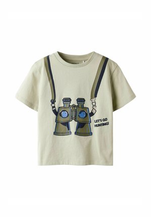 Camiseta infantil verde claro con prismáticos impresos y texto "¡Vamos de caza!" en el frente.