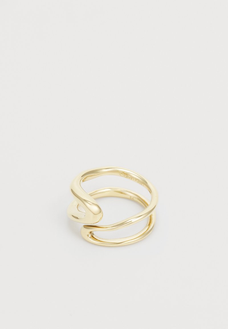 Ring i gulltone med en vridd design og glatte, blanke overflater. Åpen i endene med avrundede detaljer, laget av metall.