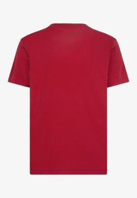 Camiseta corta de manga roja hecha de tela suave, con cuello redondo y una espalda lisa sin ningún patrón o acento visible.