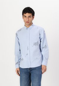 Light blue button-up shirt in soft fabric, featuring black insect illustrations on the front and sleeves, with a chest pocket and pointed collar.
