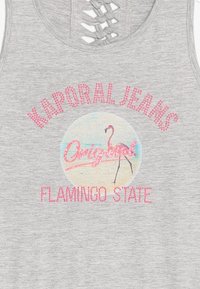 Szary top bez rękawów z krzyżującym się wzorem na plecach. Ozdobiony różowymi kamieniami szlachetnymi w formie napisu oraz okrągłą grafiką flaminga z tekstem "Stan Flaminga".