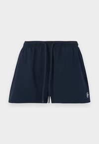 Βαμβακερά σορτς σε ναυτικό μπλε χρώμα με ελαστική μέση, κορδόνι και μικρό λογότυπο στην κάτω αριστερή ρεβέρ. Ομαλή υφή, μήκος μέχρι το γόνατο.