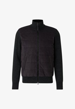 Czarna pikowana kurtka z wysokim kołnierzem i zapięciem na suwak z przodu. Ciemnoszare rękawy i boczne kieszenie. Tkanina o fakturze, sportowy design.