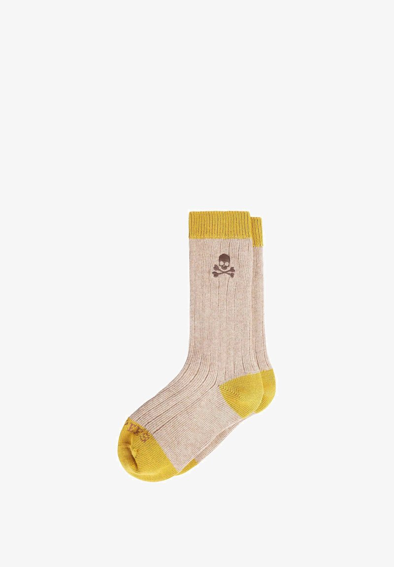 Calcetín beige de canalé con puño, talón y punta en color mostaza, que presenta un pequeño logotipo de calavera y huesos cruzados en la parte del tobillo.
