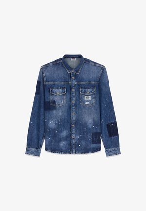 Jeanshemd in mittlerem Blau mit einem verwaschenen Look, zwei Brusttaschen, silberne Metallknöpfe und unterschiedlich gefärbte blaue Flickenakzente. Weiße Sprenkler sind vorhanden.