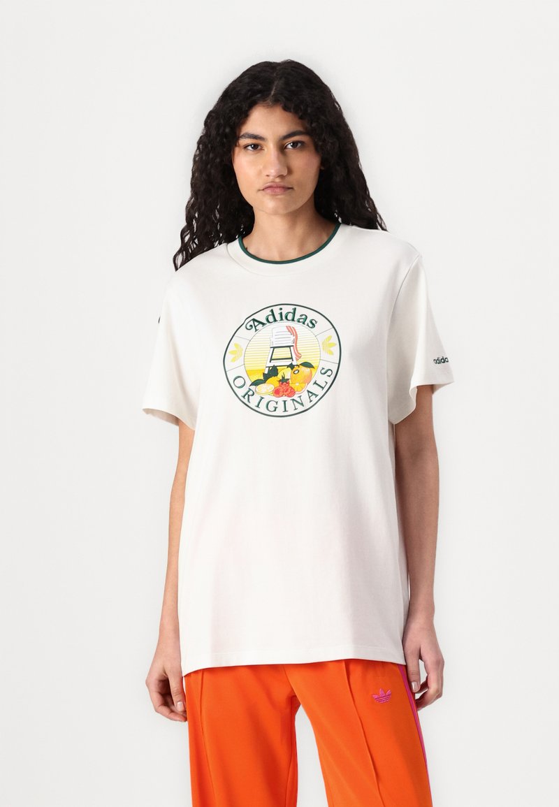Bela bombažna majica s krožno zelenim ovratnikom, ki ima barvit okrogel grafični motiv s tekstom "Adidas Originals" v središču.
