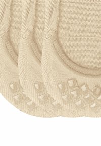 Beige usynlige sokker laget av strikket stoff, med et teksturert grep mønster på bunnen for ekstra grep. Tre par vist.