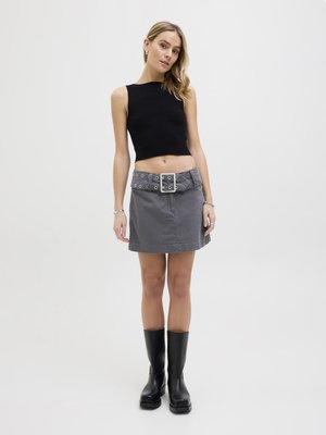 Top de cropped negro con canalé, falda de mezclilla gris con cinturón que presenta grandes ojales, y botas negras hasta la rodilla. Diseño minimalista y silueta ajustada.
