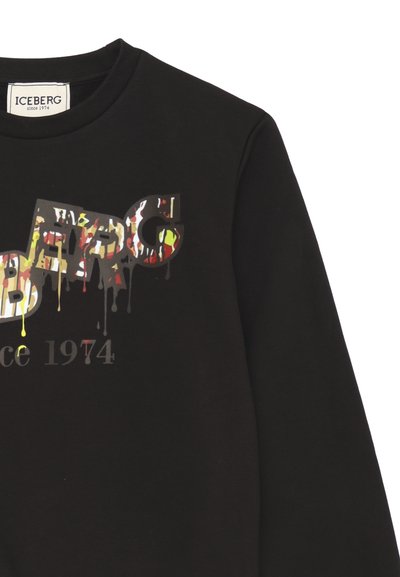 Felpa nera con logo grafico multicolore effetto vernice colante e testo "dal 1974" in basso.