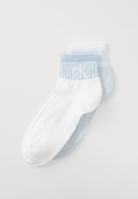 Calzini alla caviglia in cotone bianchi e azzurri chiari, con gambali a coste e loghi discreti. Texture morbida con una vestibilità confortevole.