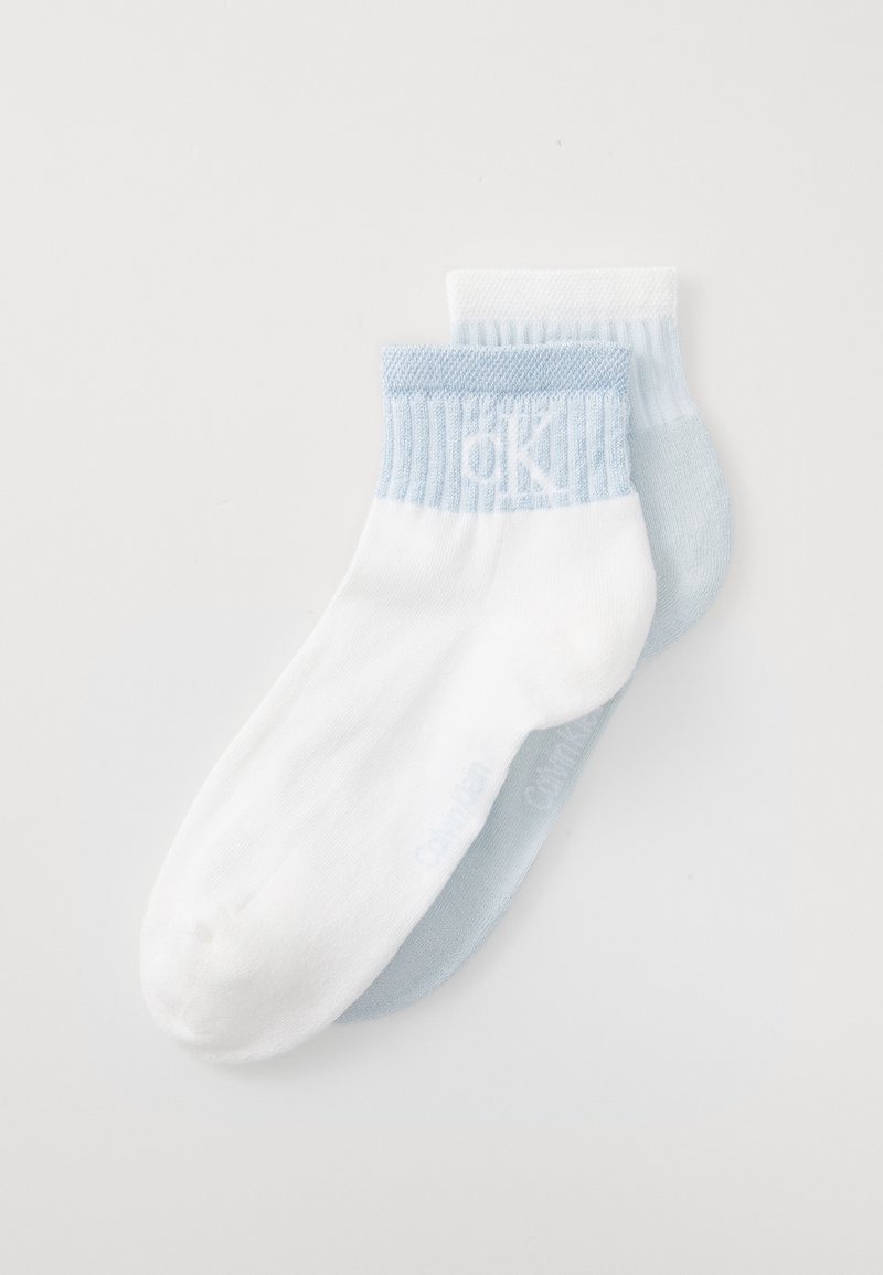 Calzini alla caviglia in cotone bianchi e azzurri chiari, con gambali a coste e loghi discreti. Texture morbida con una vestibilità confortevole.