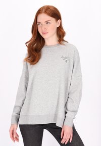 Sweatshirt gri cu o croială lejeră, având mâneci lungi, tiv ribat și text brodat pe piept. Material din bumbac moale.