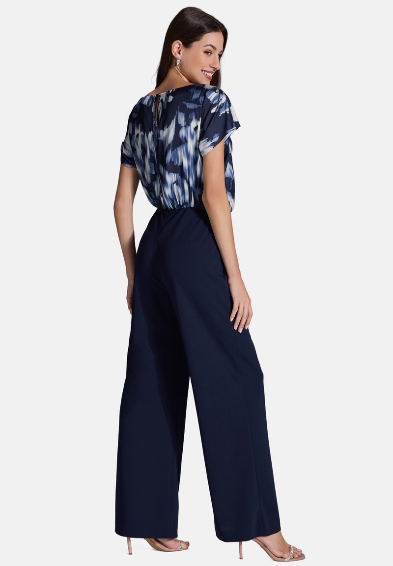 Un pantalon large marine associé à un haut à manches courtes à motif bleu et blanc. Inclut un détail en forme de clef au dos et une texture de tissu lisse.