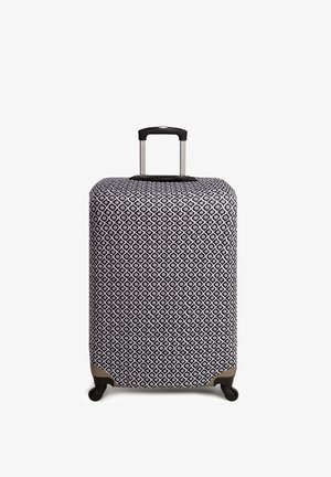 Czarna i biała walizka z twardą skorupą, teleskopową rączką, czterema kółkami i beżowymi akcentami u podstawy.