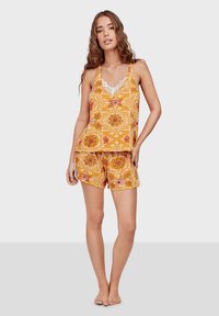 Yellow patterned pajama set featuring a sleeveless top with lace accents and matching shorts, both made of lightweight fabric.