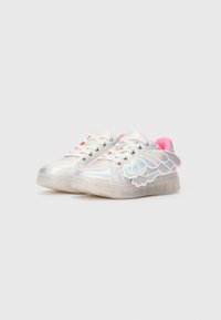 Zapatillas iridiscentes para niños con cordones blancos, suelas translúcidas, forro interior rosa y adornos decorativos en forma de alas a los lados.