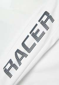 Witte stoffen t-shirt met in het zwart gedrukte, vetgedrukte tekst "RACER" die verticaal langs de mouw loopt, met een soepele textuur.