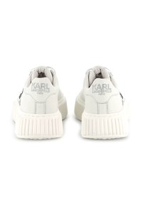 Ténis brancos de couro com solas texturizadas e robustas. Apresentam a marca "KARL LAGERFELD" embossada no calcanhar e um acabamento suave.
