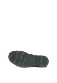 Suola di scarpa in gomma nera con motivo di presa testurizzato. Presenta linee rialzate e indentazioni circolari per la trazione. Forma leggermente curvata nella punta.