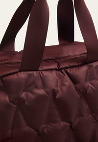 Bordó steppelt szövet táska texturált felülettel, dupla vastag pántokkal és formális kialakítással. A belső tér tágasnak és bélésnek tűnik.