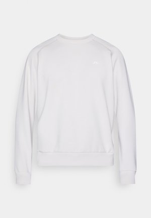 Fehér pulóver hosszú ujjakkal, kerek nyakkivágással, bordázott mandzsettákkal és szegéllyel. Finom logó található a mellkason, és sima anyagú textúrával rendelkezik.