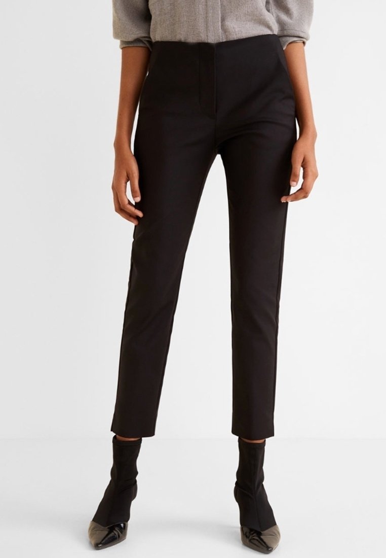 Pantaloni neri su misura realizzati in tessuto liscio, caratterizzati da una silhouette aderente, vita medio-alta e lunghezza cropped, abbinati a tacchi neri.
