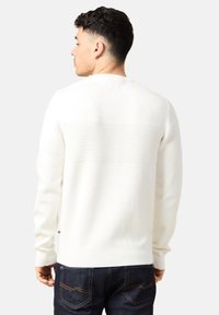 Maglione bianco a maglia con una striscia testurizzata orizzontale sulla parte superiore della schiena. Polsini e orlo a costine. Abbinarlo a jeans blu scuri.