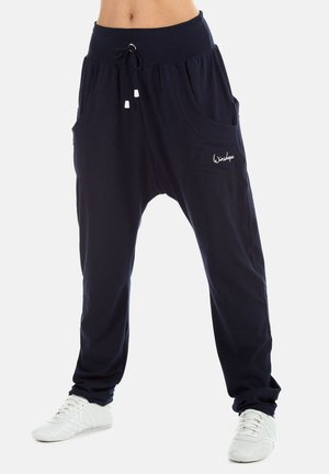 Navy blue relaxed-fit harem pants with a wide elastic waistband, drawstring closure, and two large side pockets. White stitching detail.