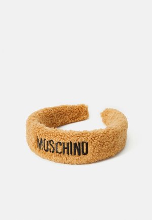 Bandeau doux et moelleux de couleur moutarde avec un logo noir "MUSCHINO". Forme arrondie avec un tissu texturé. Convient pour un look décontracté.