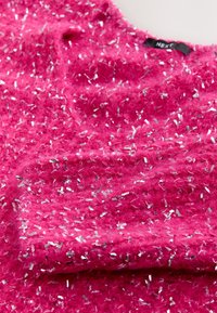 Zachtroze textiel met metalen zilverkleurige vlekjes, met een zachte, gestructureerde oppervlakte en een lichte glans. Stof valt in plooien.