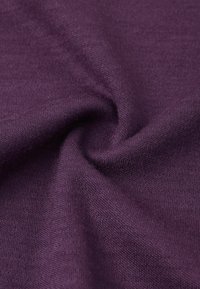 Tessuto viola con una consistenza liscia, mostrato in un primo piano che evidenzia i sottili motivi a maglia e le caratteristiche morbide e flessibili.