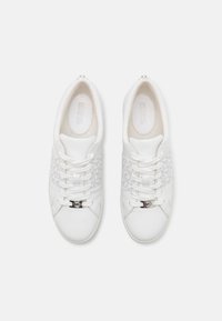 Hvite sneakers med et teksturert stoffpanel i midten med logo, snøring og glatt skinn på overdelen. Sølvdetaljer på snørene.