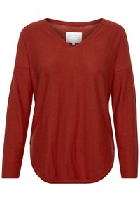 Pull à manches longues couleur rouille avec col en V, ourlet arrondi et coupe ample, présenté sur fond blanc.