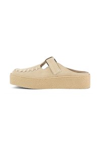 Beige suede clog-style shoe with a textured platform sole, featuring woven detailing on the upper and an adjustable strap across the opening.