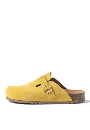 Zueco amarillo de ante con tira ajustable y hebilla dorada, plantilla de corcho contorneada y suela marrón texturizada.