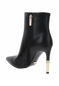 Stivale alla caviglia in pelle nera con punta affusolata, zip laterale e tacco alto sottile, dotato di un accento metallico dorato con strass.