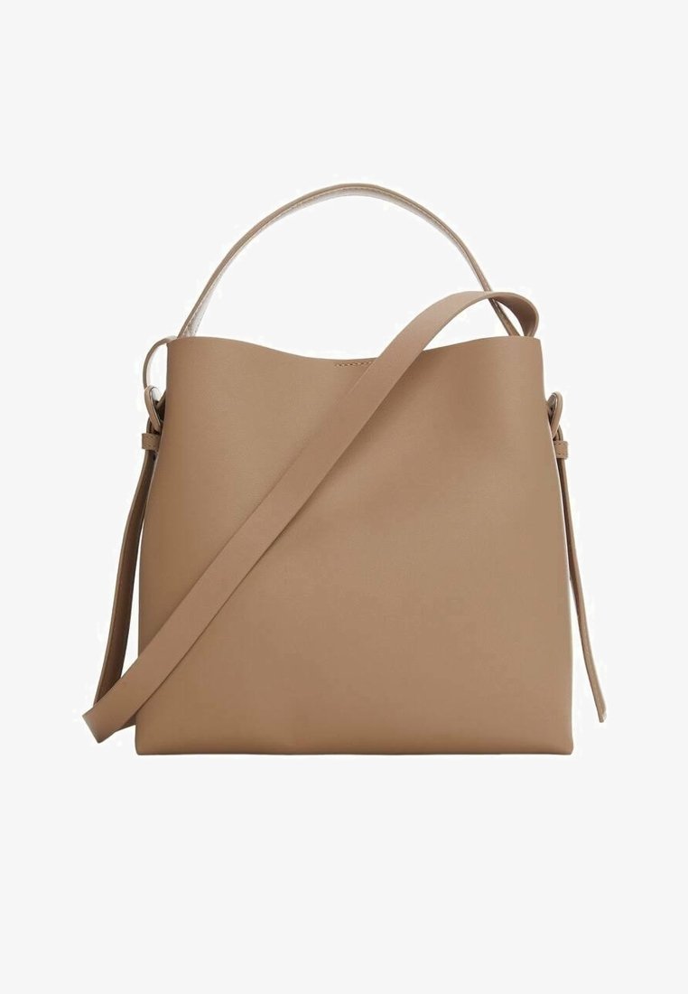 Sac à main en cuir beige avec une poignée supérieure et une bandoulière longue réglable, rectangulaire avec des bords arrondis doux.