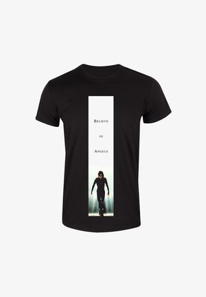 T-shirt in cotone nero con un pannello verticale bianco centrale che riporta il testo "Credi negli Angeli" e un'immagine in silhouette.