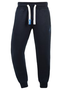 Navy sweatpants made of soft fabric, featuring a drawstring waist with white cords, side pockets, and ribbed cuffs for a snug fit.