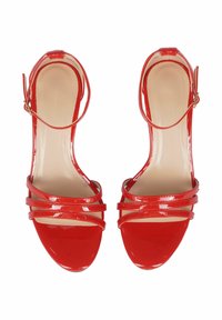 Sandali con tacco alto in vernice rossa, caratterizzati da molteplici cinghie incrociate e cinghie alla caviglia, con una superficie liscia e una punta appuntita.